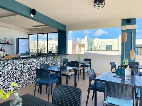 a restaurant with tables and chairs and a bar at The Boat Condo by Andiani Travel in Playa del Carmen