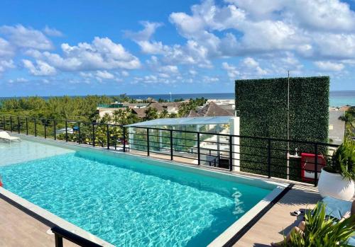 a swimming pool on a balcony with the ocean in the background at The Boat Condo by Andiani Travel in Playa del Carmen