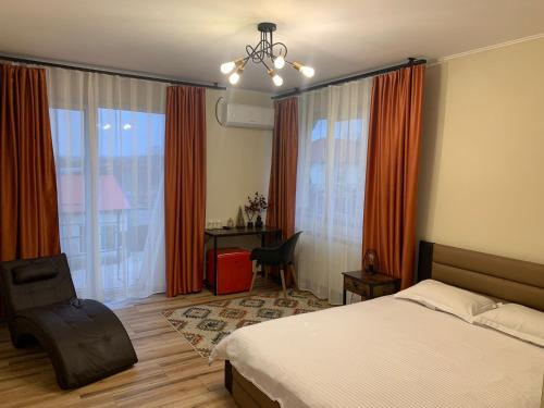 a bedroom with a bed and a desk and a window at pensiunea grecu in Lugoj
