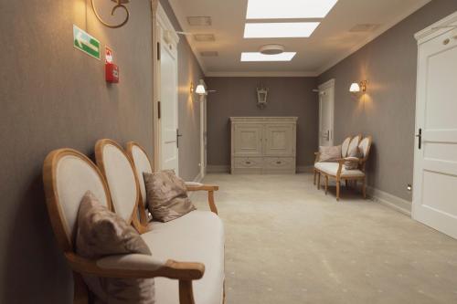 a waiting room with chairs and a white couch at Hotel Adler in Byczyna