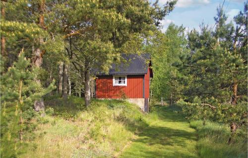a red house in the middle of a forest at Holiday Home Kanhult Co Ericson Västervik in Västervik
