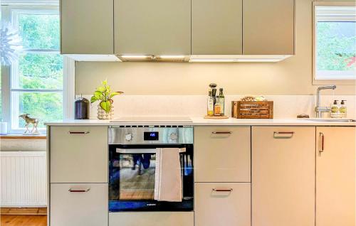 a kitchen with white cabinets and a stove top oven at Holiday Home Kanhult Co Ericson Västervik in Västervik