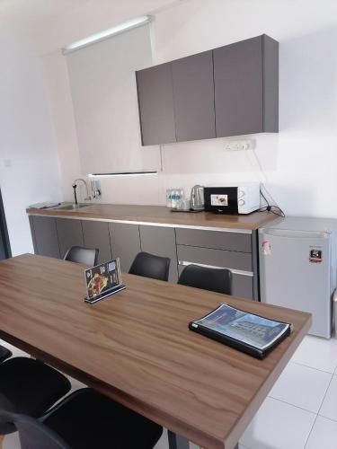 a kitchen with a wooden table with chairs at CityViu at Imperio Professional Suites in Alor Setar