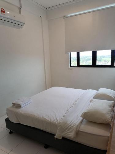 Bett in einem weißen Zimmer mit Fenster in der Unterkunft CityViu at Imperio Professional Suites in Alor Setar