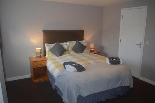 a bedroom with a large bed with two lamps on it at The Queen Victoria in Snettisham