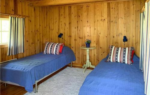 two beds in a room with wooden walls at Holiday Home Kanhult Co Ericson Västervik in Västervik