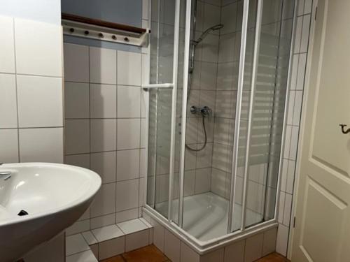 a bathroom with a shower and a sink at Altes Standesamt Studiowohnung in Oldsum