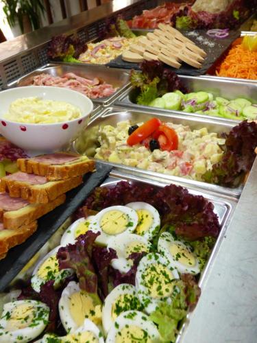 a buffet filled with different types of food in trays at Auberge des Avenières in Les Avenières