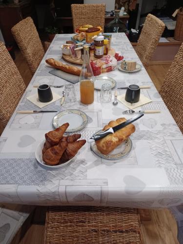 einen langen Tisch mit Teller mit Lebensmitteln drauf in der Unterkunft Chambre d'Emma 