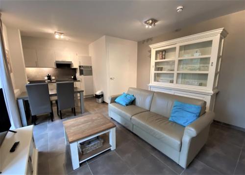 a living room with a couch and a table at Triton suite Duinhof - Stijn Albrechtsstraat 1-6 in Cadzand