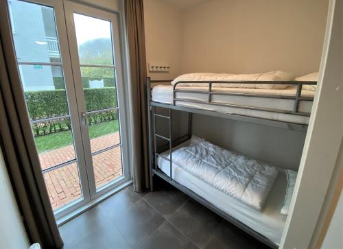 a room with two bunk beds and a window at Triton suite Duinhof - Stijn Albrechtsstraat 1-6 in Cadzand