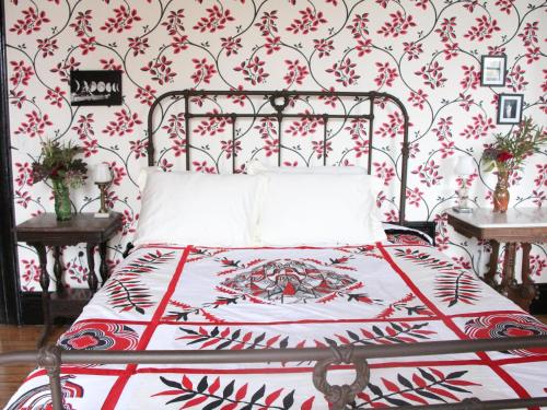 a bedroom with a bed with a red floral wallpaper at The Wedding Cake House in Providence