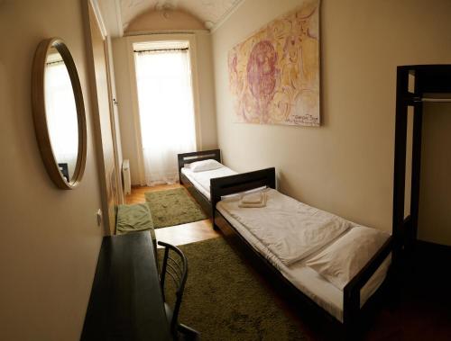 two beds in a room with a mirror and a window at Old City Hotel in Lviv