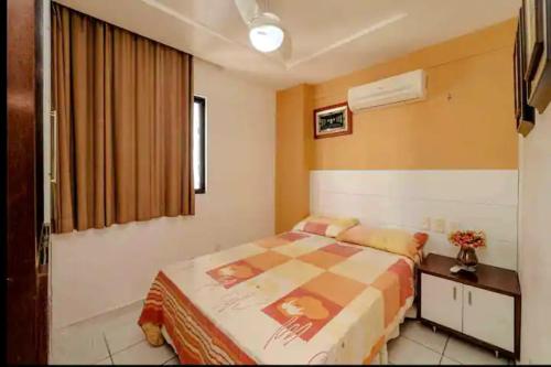 1 dormitorio con cama, escritorio y ventana en Apartamento aconchegante, en Natal