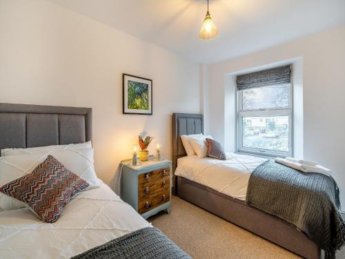 a bedroom with two beds and a window at Raven House in Kendal