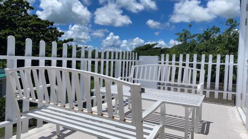 two white benches sitting next to a white fence at 獨棟山水心旅棧 in Kenting