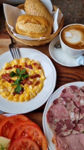 a table with plates of food and a cup of coffee at Hotel Adler in Byczyna