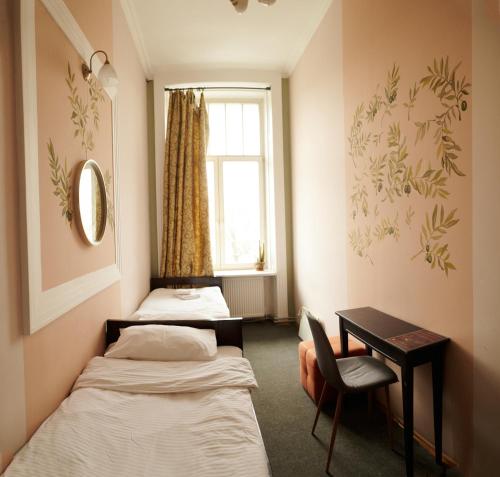 um quarto com 2 camas, uma secretária e uma janela em Old City Hostel em Lviv