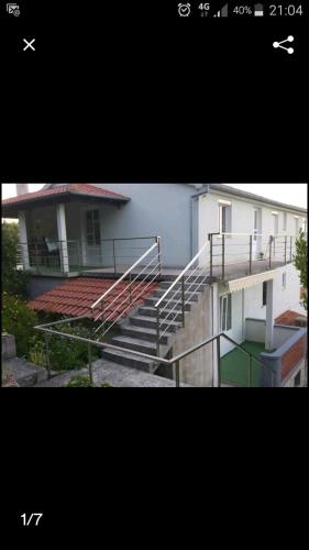 two photographs of a building with stairs and a house at Cozy apartman in Luka