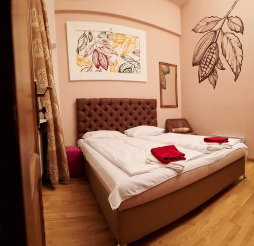 a bedroom with a bed with white sheets and red towels at Old City Hotel in Lviv