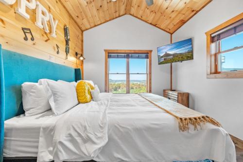 een slaapkamer met een groot wit bed en een houten plafond bij A Song Writers Paradise, Hot Tub Once Owned By Dolly Parton in Sevierville