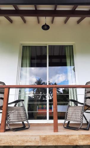 two benches sitting on a porch with a window at Victoria Views Resort Kandy in Digana