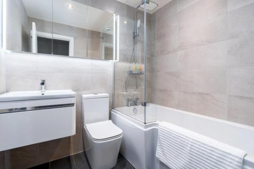 a bathroom with a toilet and a sink and a tub at Very Close to Manchester Airport and Wythenshawe Hospital - Tailored for Monthly and Long Term Stays in Sale