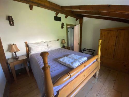 a bedroom with a bed with a wooden frame at The Olde Angel Inn in Niagara on the Lake