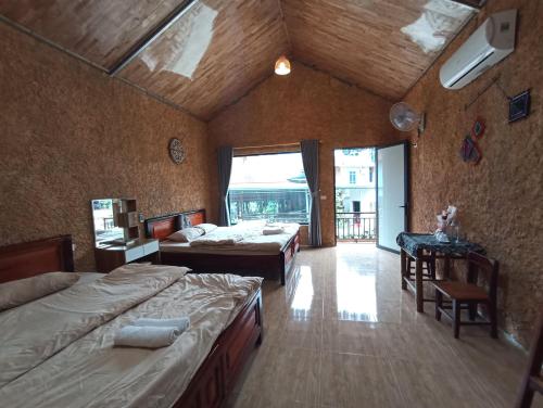 ein großes Schlafzimmer mit 2 Betten und einem großen Fenster in der Unterkunft Thao Ly Homestay Mai Chau in Hòa Bình