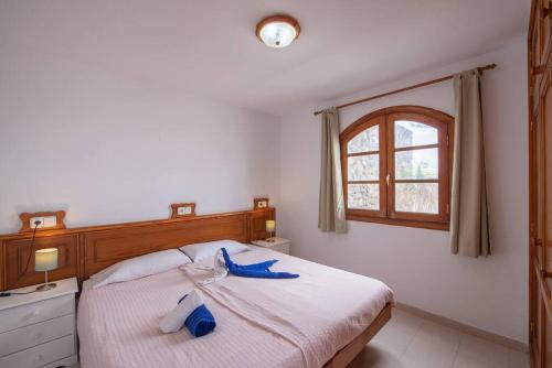 una camera da letto con un letto con asciugamani blu di Precioso apartamento para nudistas y naturistas. a Charco del Palo