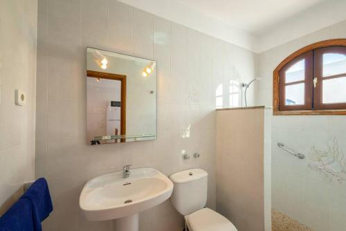 bagno con lavandino, servizi igienici e specchio di Precioso apartamento para nudistas y naturistas. a Charco del Palo