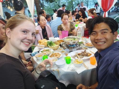 Un uomo e una donna seduti a un tavolo con del cibo di Bà Ngoại Homestay a Cà Mau