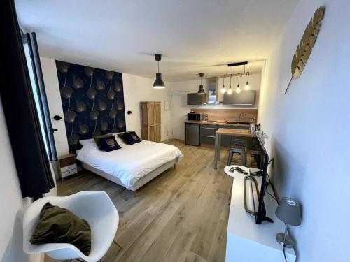 a small bedroom with a bed and a kitchen at ALP Chartres - Cosy studio au cœur de Chartres avec Parking in Chartres
