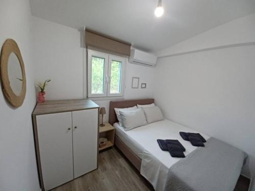 ein Schlafzimmer mit einem weißen Bett und einem weißen Schrank in der Unterkunft Seaside house for 8 close to Olympia & the beach in Levendokhórion