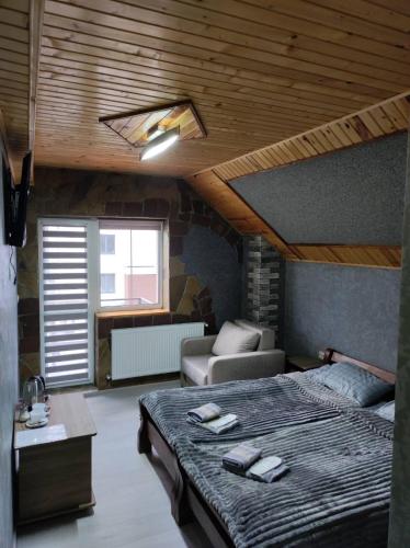 a bedroom with a large bed and a room with a couch at Margo in Yaremche