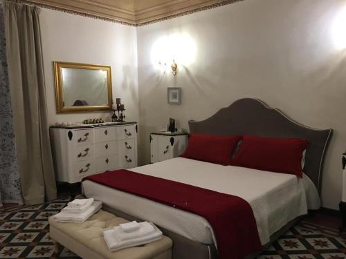 1 dormitorio con cama con almohadas rojas y espejo en La piazza è mia, en Cefalú