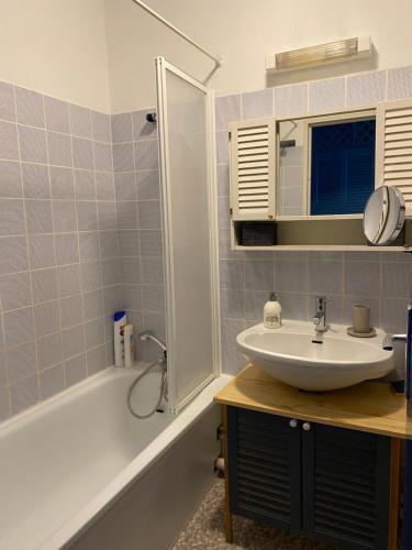 a bathroom with a sink and a tub at Les Marinas de Cassy in Lanton