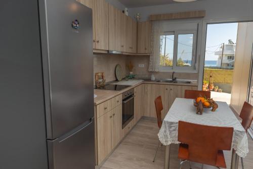 a kitchen with a table and a stainless steel refrigerator at Stegna Holiday in Archangelos