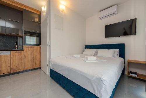 a bedroom with a large bed with a tv on the wall at Appartements VIR in Vir