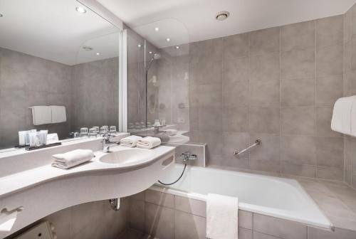 y baño con lavabo, bañera y espejo. en Rosenburg Hotel Brugge, en Brujas