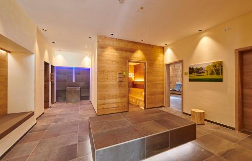 a hallway of a home with wooden walls and a tile floor at Bachhof Resort Apartments in Kirchroth