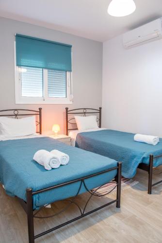 two beds in a room with towels on them at Stegna Holiday in Archangelos