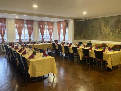 Hotel da Luca في Herzogenbuchsee: غرفة طعام مع طاولات وكراسي مع طاولة قماش صفراء