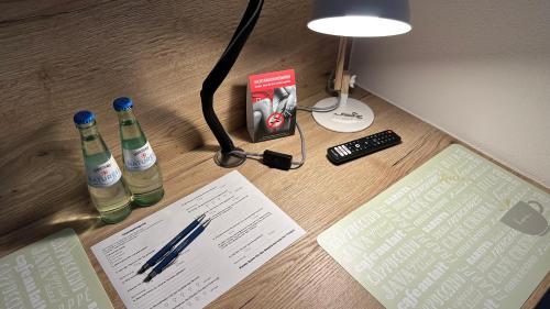 a desk with two bottles of water and a lamp at Pension zum Winterberg in Elsterwerda