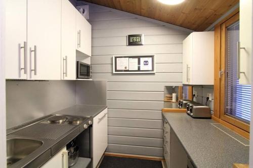 a kitchen with white cabinets and a counter top at Lomariihi 1 in Muurame