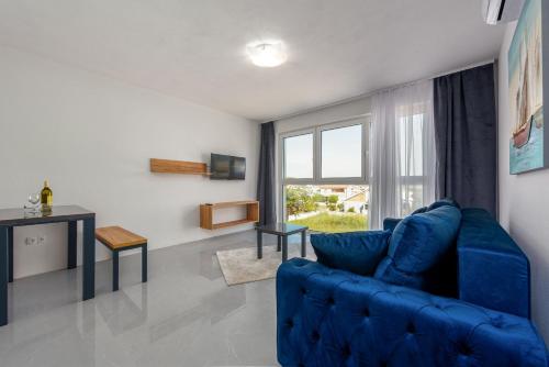 a living room with a blue couch and a window at Appartements VIR in Vir