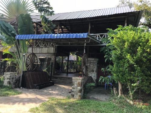 a small house with a blue roof and a yard at Captain Chim's Guest House in Kep