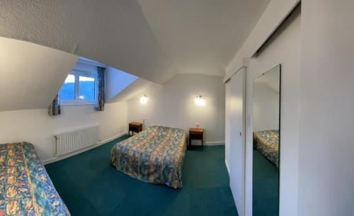 ル・トリーにあるGites de la Cascadeのベッド2台と鏡が備わるホテルルームです。