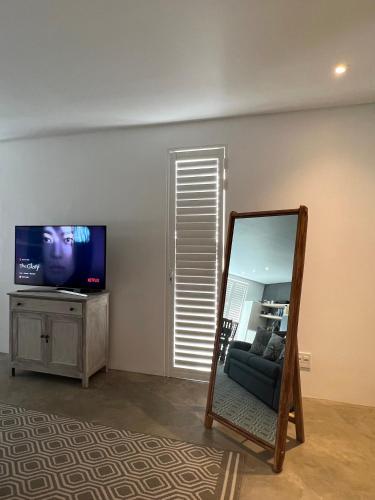 a living room with a mirror and a tv at Flip Flops Villa in Yzerfontein