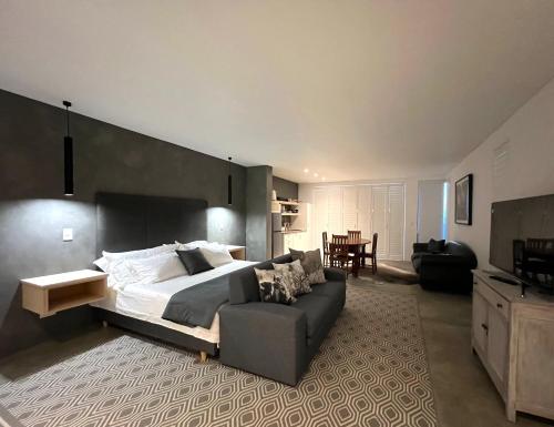 1 dormitorio con 1 cama grande y 1 sofá en Flip Flops Villa, en Yzerfontein